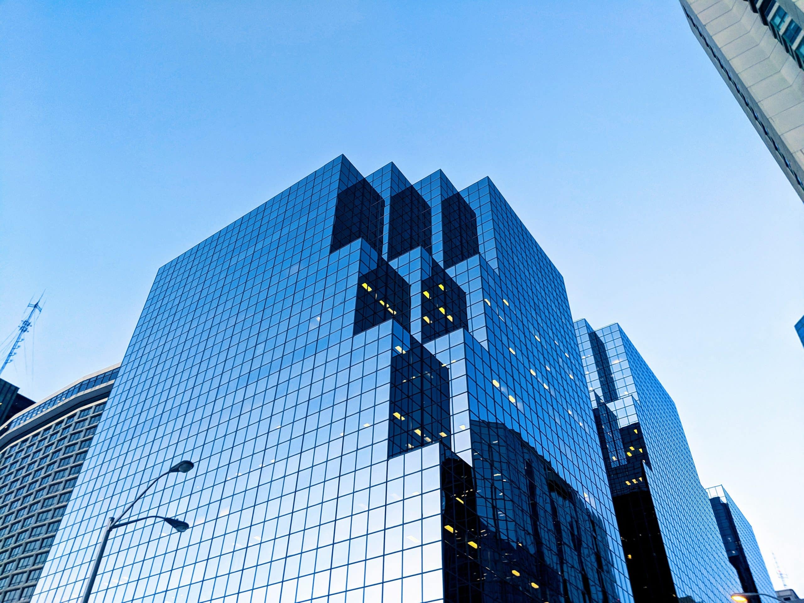 Photo of a large office building reflecting the blue sky.